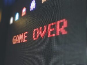 An arcade game displays the text "Game Over"